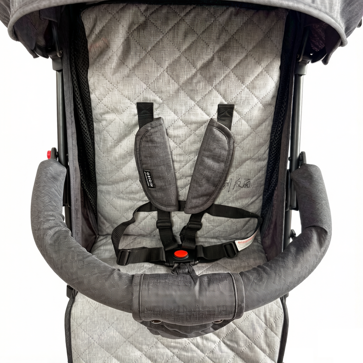 Close up of the ORIGIN Bellbird seat showing the 5 point harness, bumper bar, and cushioned liner