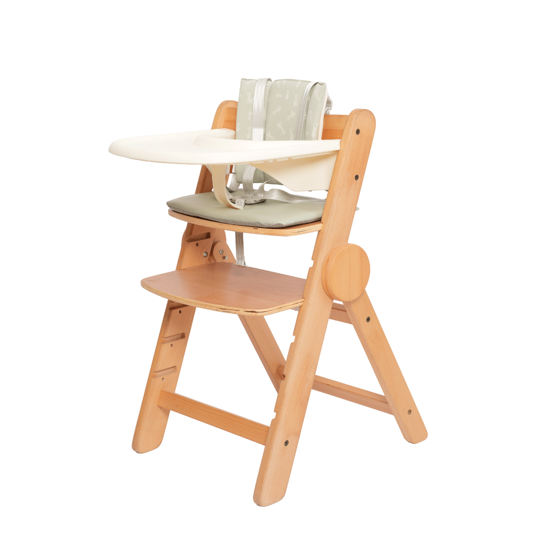 Wooden high chair with a white tray and green cushion on a white background