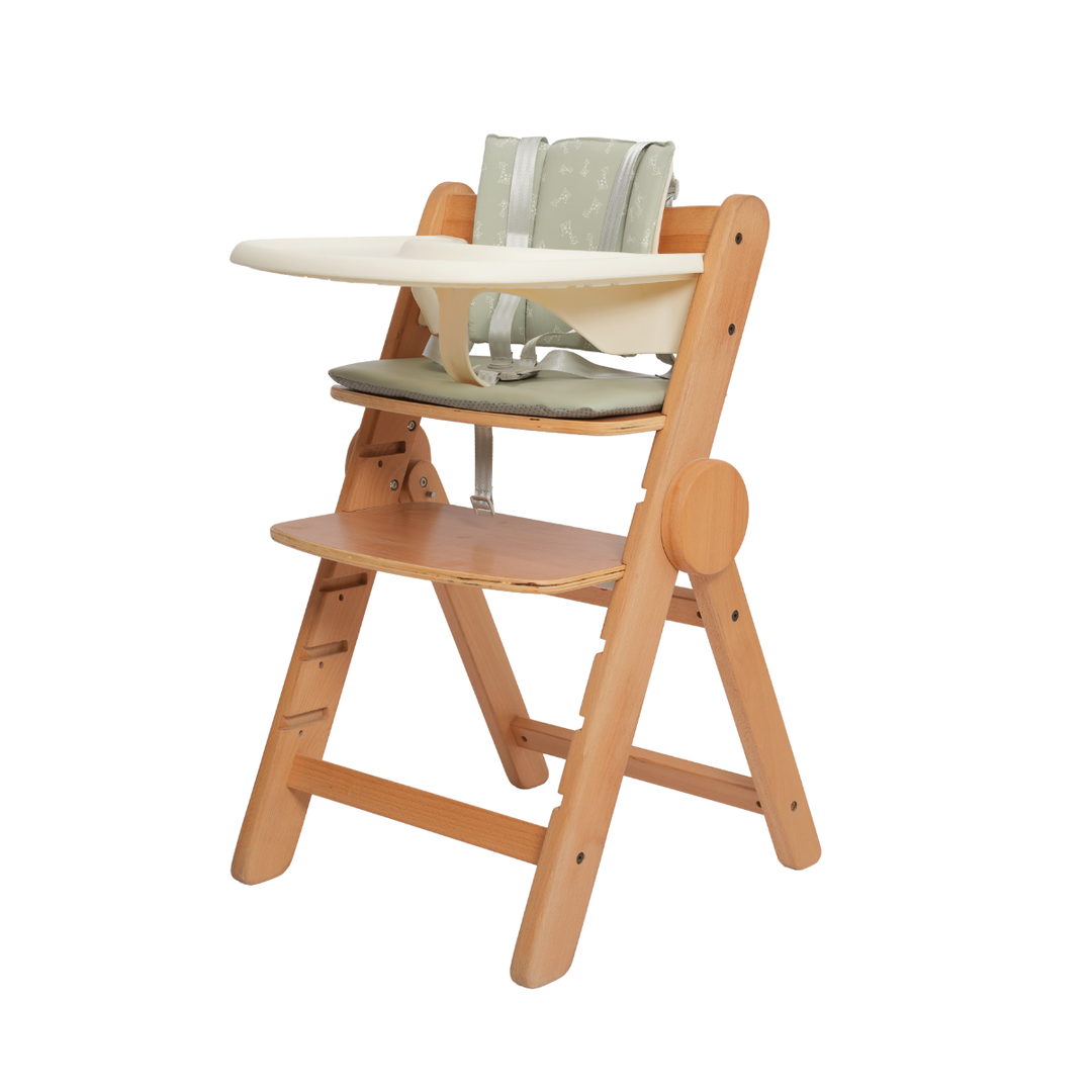 Wooden high chair with a tray and green cushion on a white background
