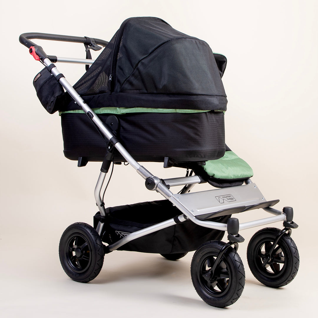 full shot of a mountain buggy duet carrycot plus mesh cover on a matcha carrycot plus next to a duet seat 