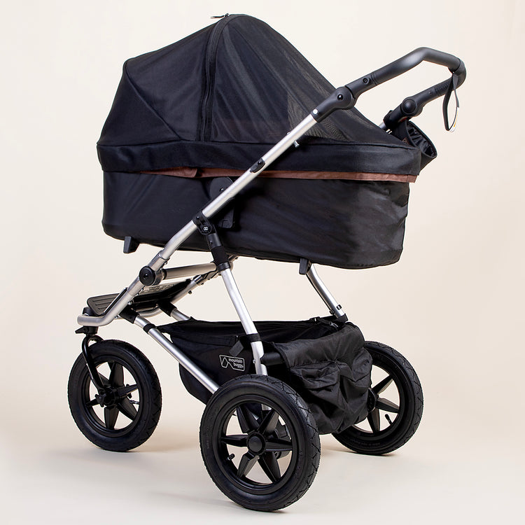 full shot of a mountain buggy urban jungle carrycot plus mesh cover on a mustang brown carrycot plus