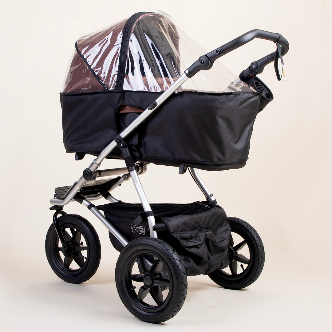 full shot of a mountain buggy urban jungle carrycot plus storm cover on a mustang brown carrycot plus