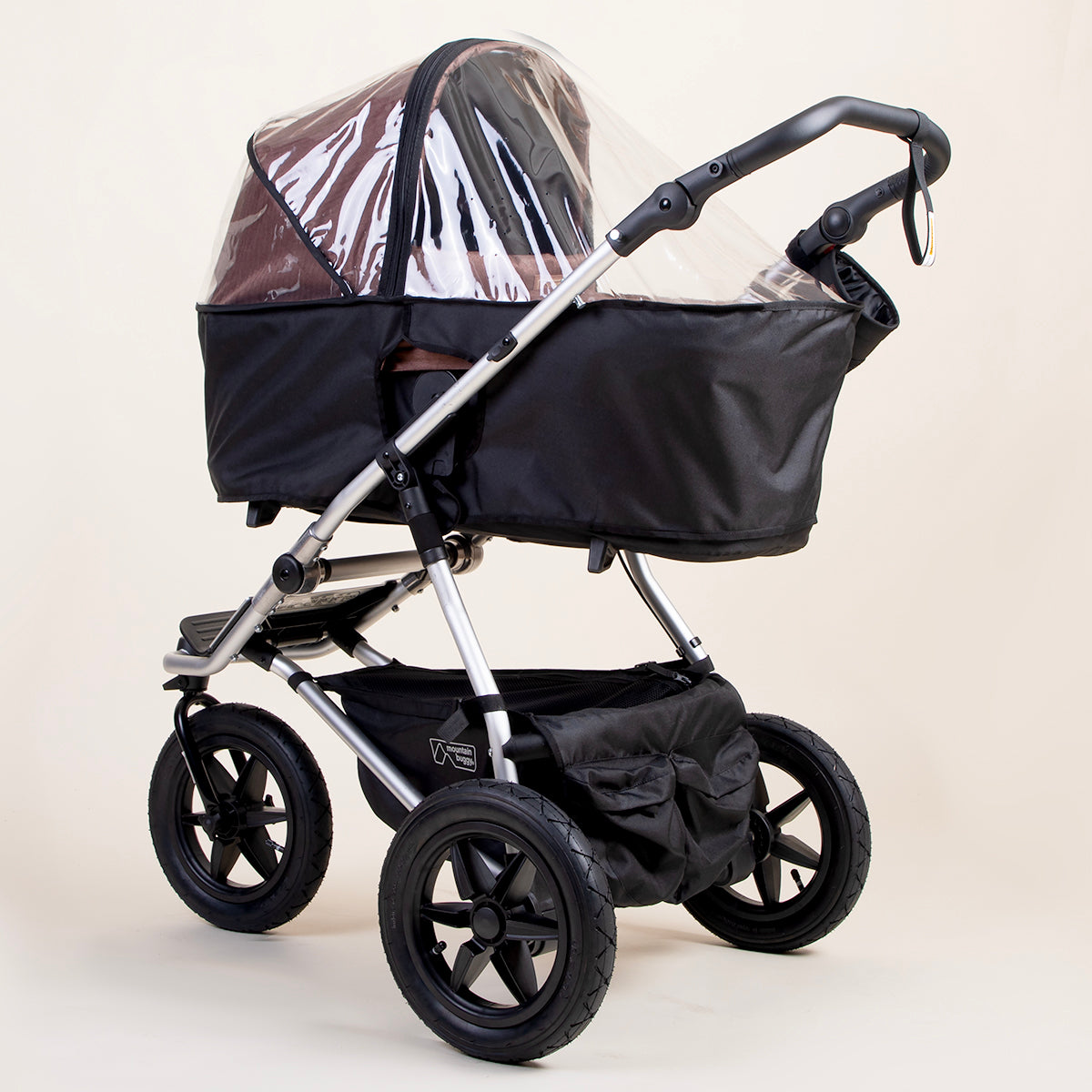 full shot of a mountain buggy urban jungle carrycot plus storm cover on a mustang brown carrycot plus