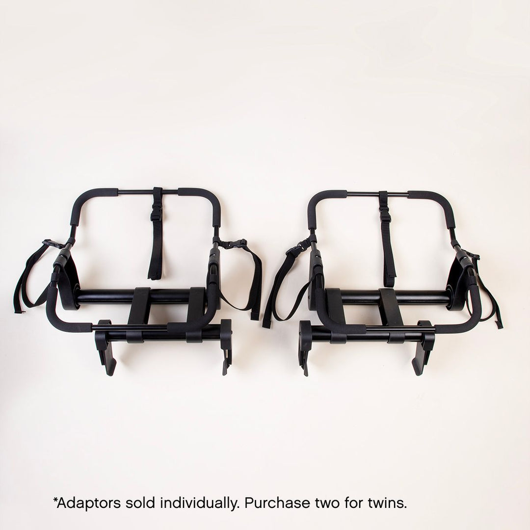 top down view of mountain buggy duet universal car seat adaptors side by side with alternating offsets on a white background