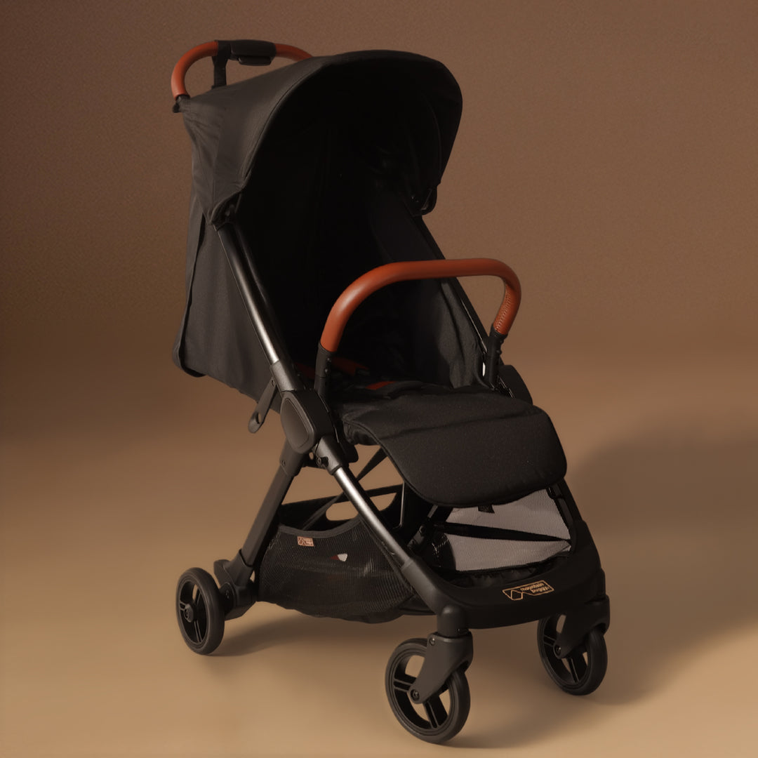 Full angled shot of the Mountain Buggy nano urban in black shown against a brown background