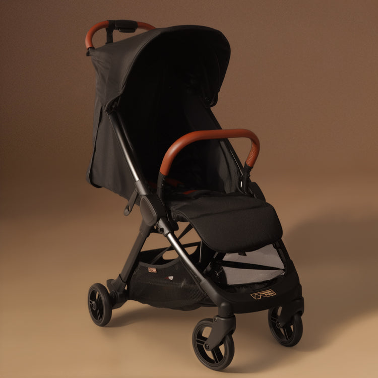 Full angled shot of the Mountain Buggy nano urban in black shown against a brown background