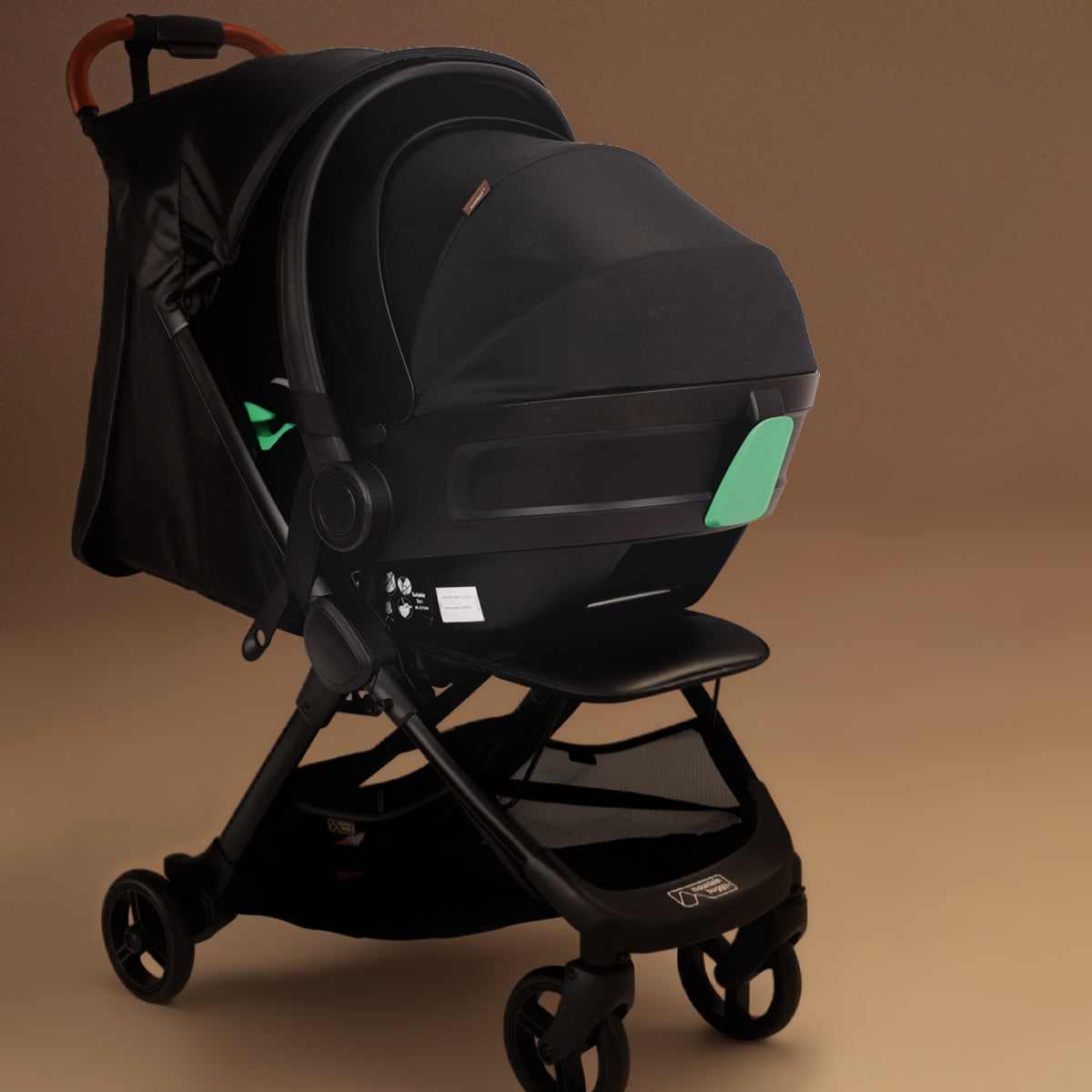 Full shot of the Mountain Buggy nano urban in black with capsule attached shown against a brown background