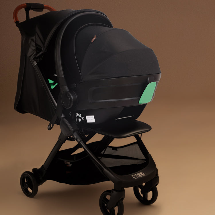 Full shot of the Mountain Buggy nano urban in black with capsule attached shown against a brown background