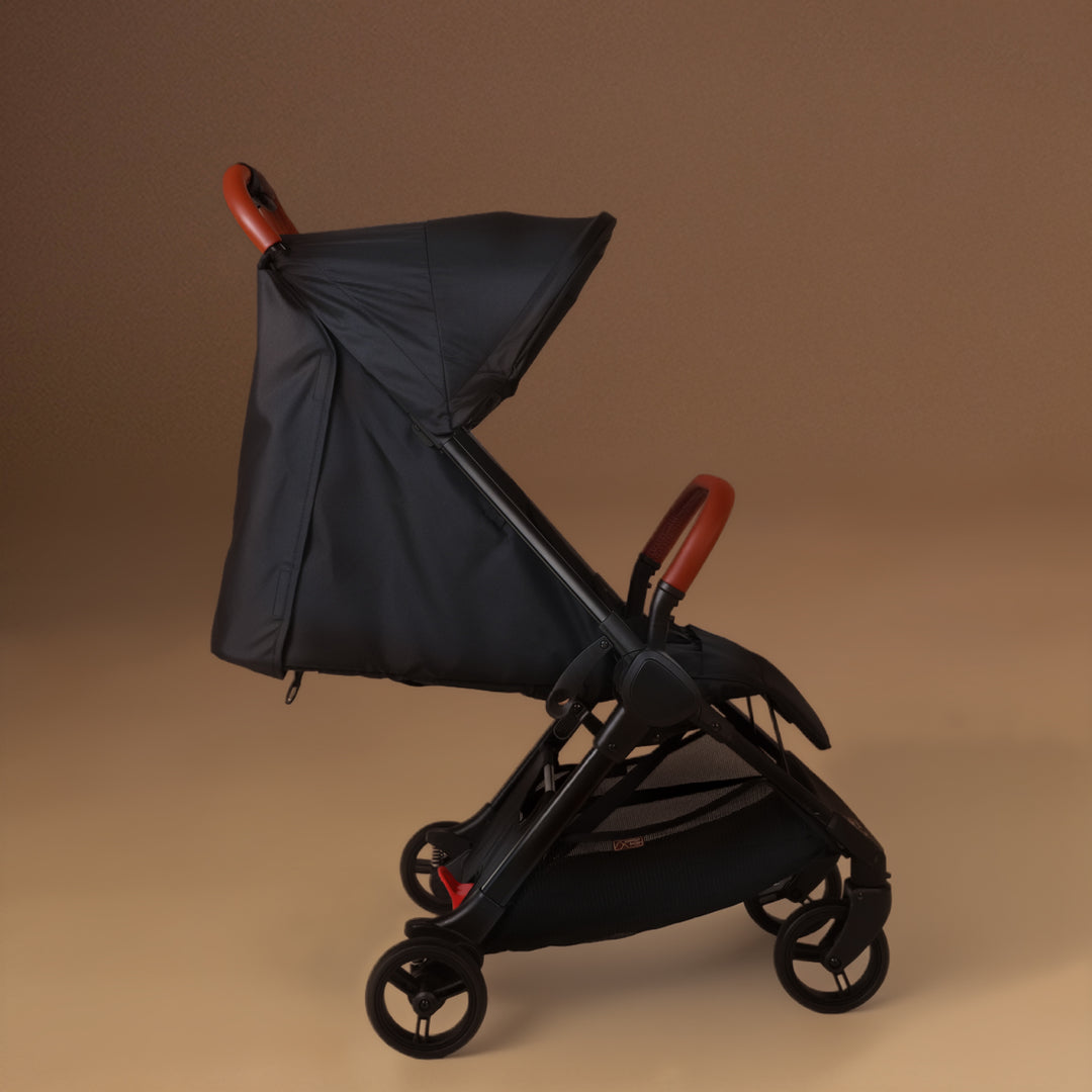 Full shot of the Mountain Buggy nano urban with the travel wheels installed in black shown against a brown background