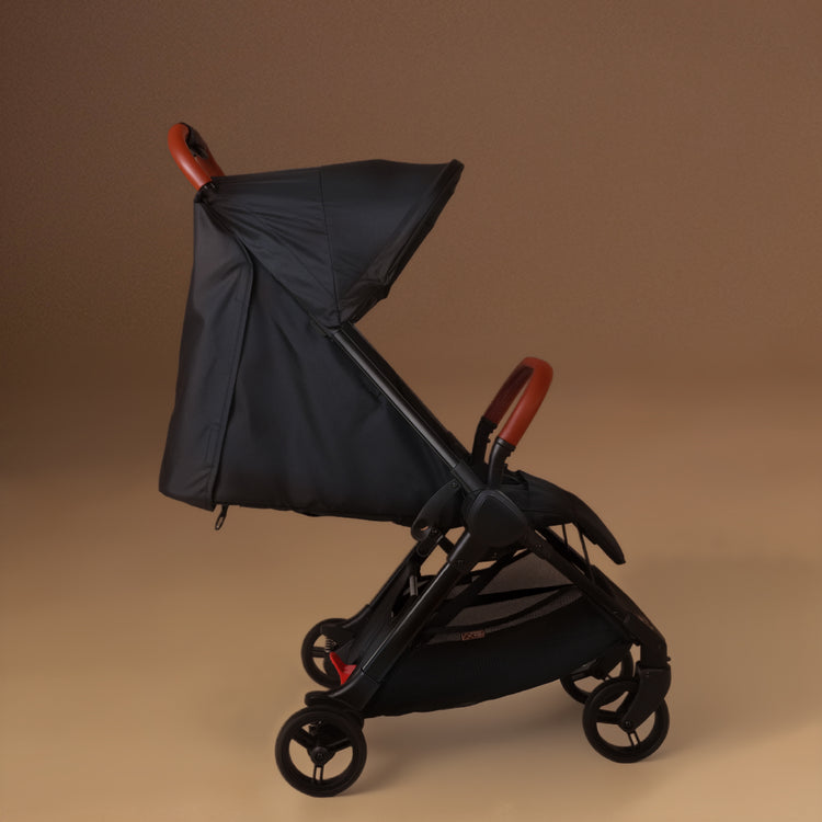 Full shot of the Mountain Buggy nano urban with the travel wheels installed in black shown against a brown background