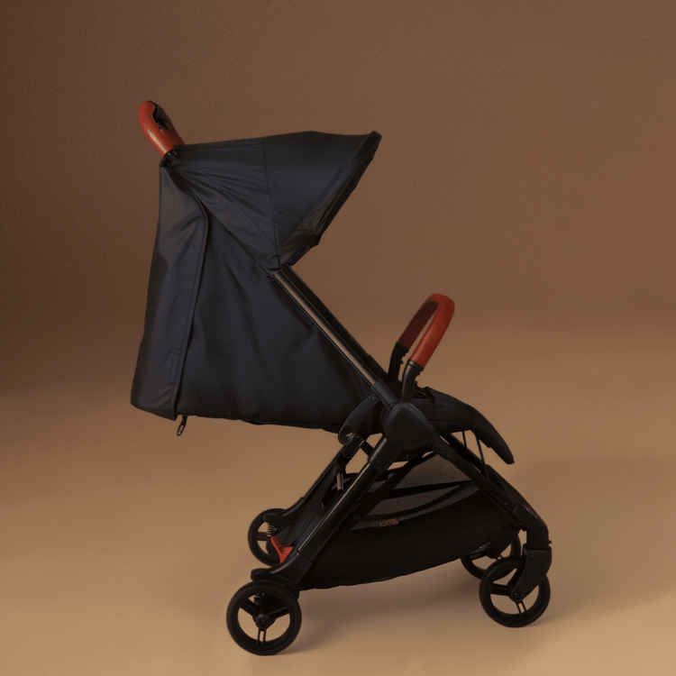 A Full shot of the Mountain Buggy nano urban in black as a GIF showing the reclining seat against a brown background