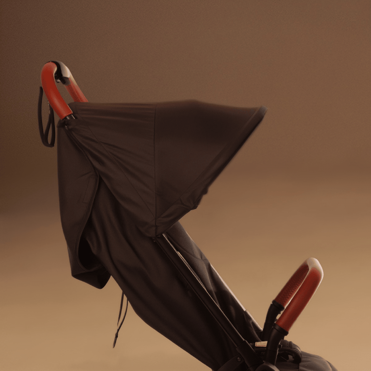 Close up shot of the Mountain Buggy nano urban in black as a GIF showing the different sunhood positions shown against a brown background