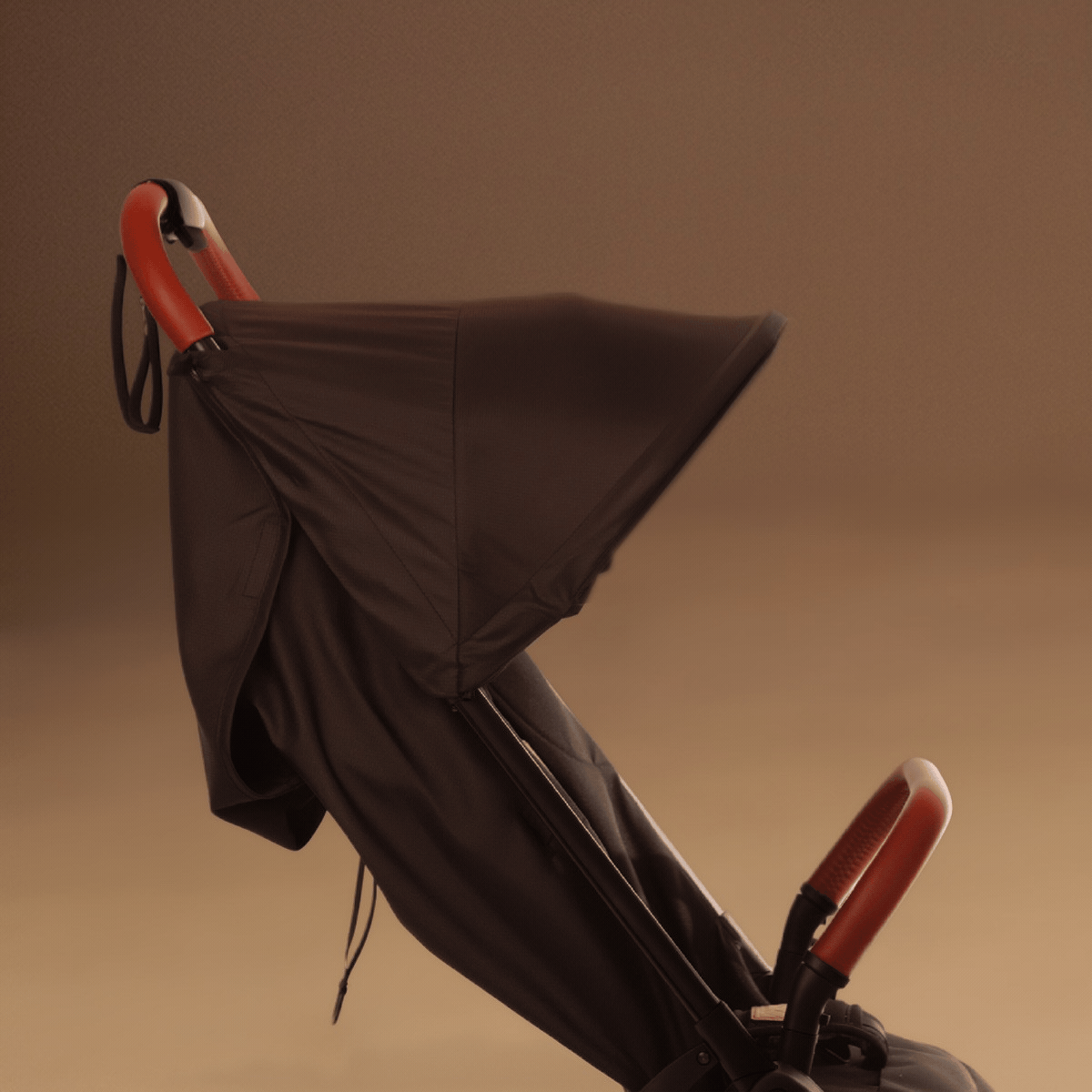 Close up shot of the Mountain Buggy nano urban in black as a GIF showing the different sunhood positions shown against a brown background