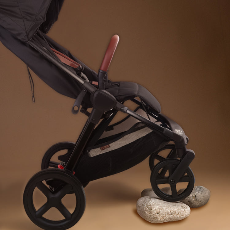 Close up shot of the Mountain Buggy nano urban in black with the larger wheels on a rock shown against a brown background