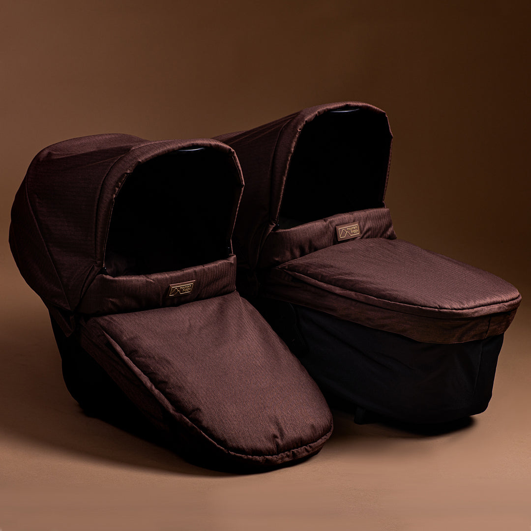 Full shot of the Mountain Buggy urban jungle carrycot plus in mustang brown in toddler mode and standard shown on a brown background