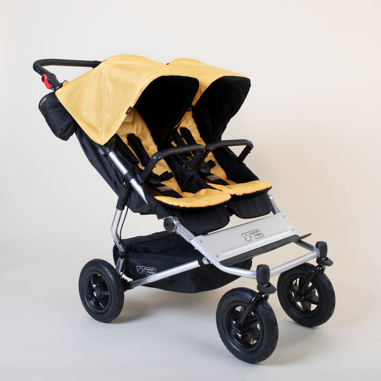 Full shot of Mountain Buggy duet in solare yellow double front facing setup on a white background