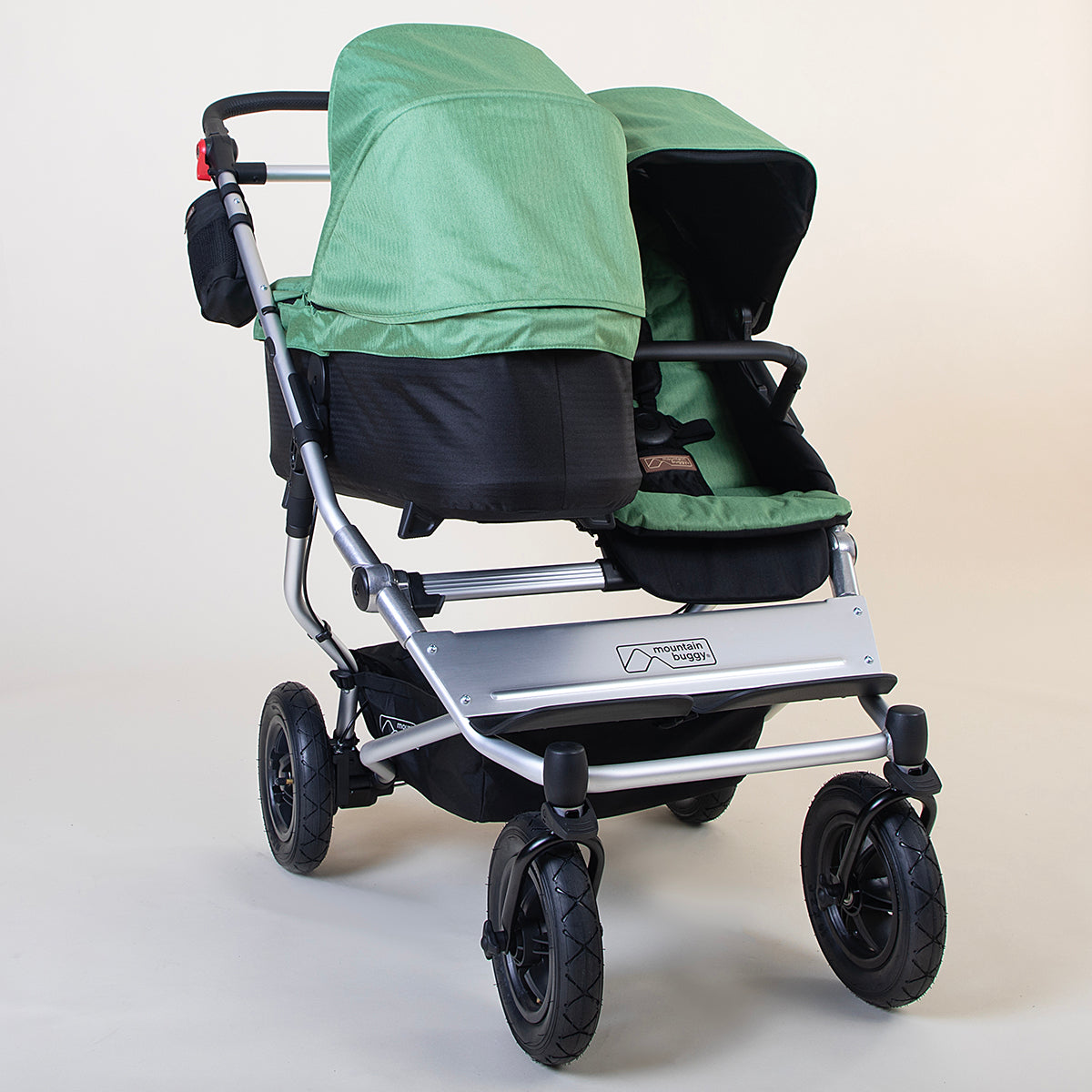 Full shot of Mountain Buggy duet in matcha green with front and rear facing setup on a white background