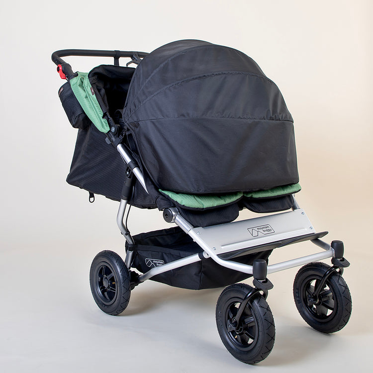 Full shot of Mountain Buggy duet in matcha green with double sunshade on a white background