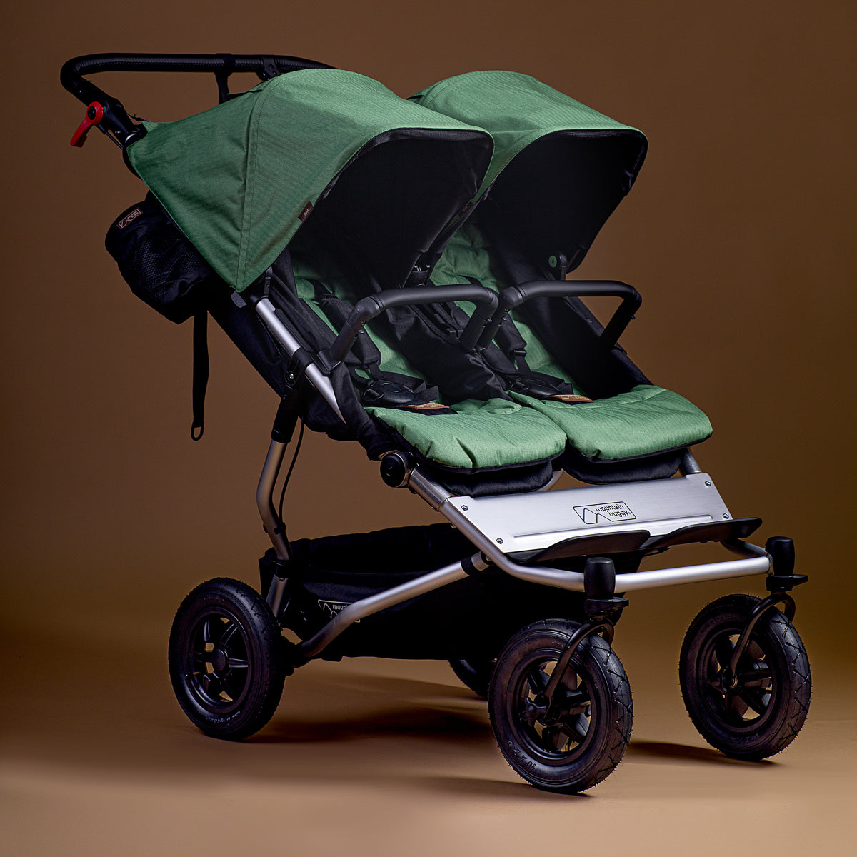 Full shot of Mountain Buggy duet in matcha green on brown background