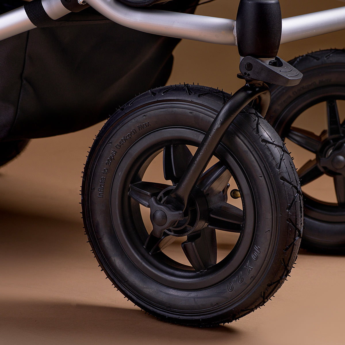 Close-up of a Mountain Buggy Duet front wheels on a brown background