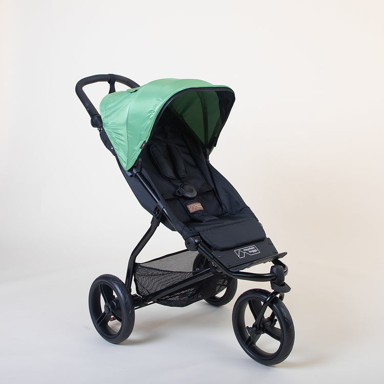Full angled shot of the Mountain Buggy swift in matcha and fully closed sun shade shown on a white background