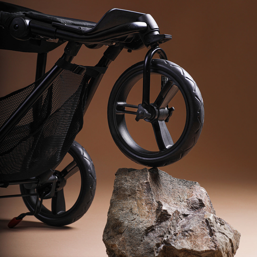 close up shot of the Mountain Buggy swift showcasing the all terrain wheels on a brown background