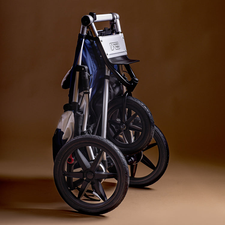 Full shot of the Mountain Buggy terrain in quartz folded up shown on a brown background