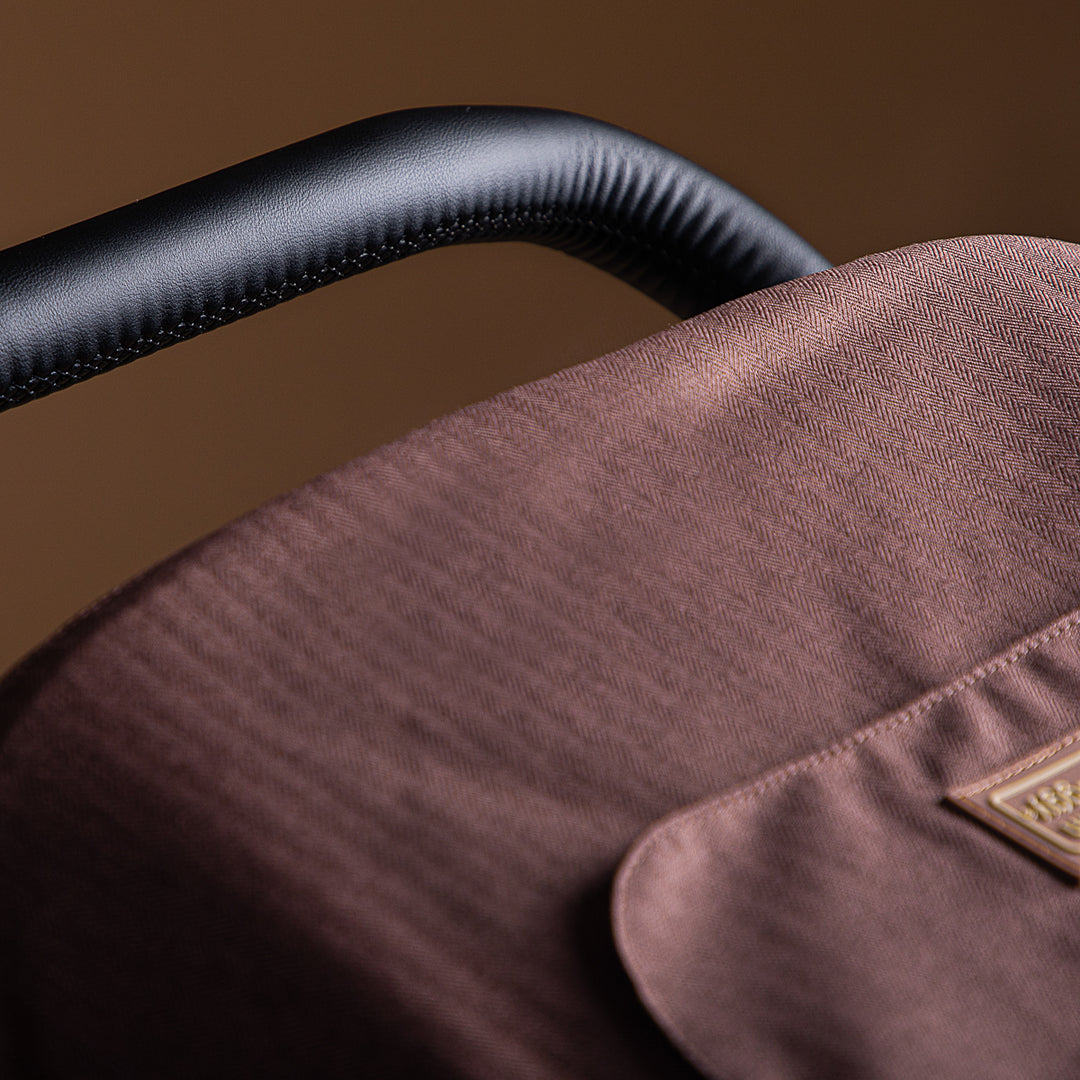 close up shot of the Mountain Buggy urban jungle sun shade in mustang brown shown on a brown background