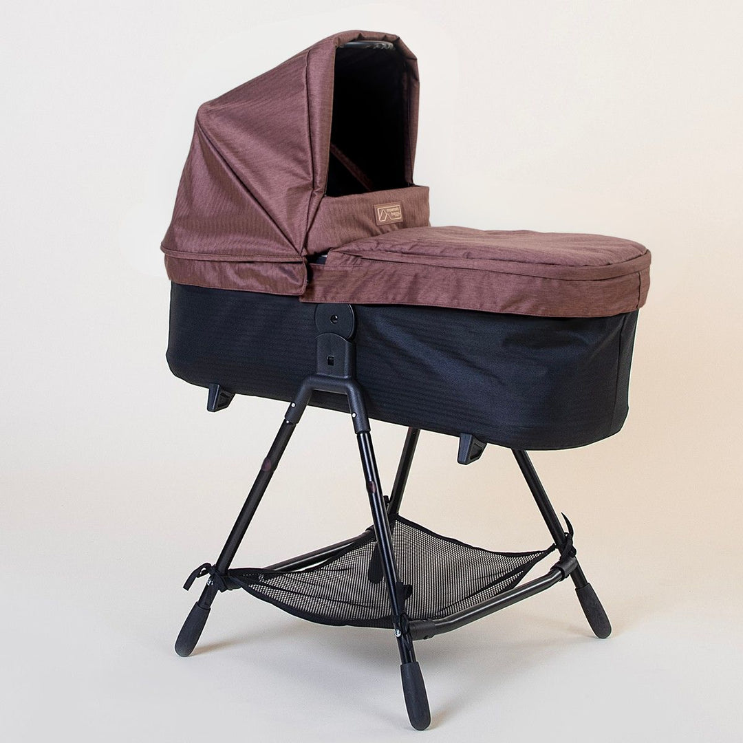 Full shot of Mountain Buggy carry cot plus for duet in mustang brown with stand on white background