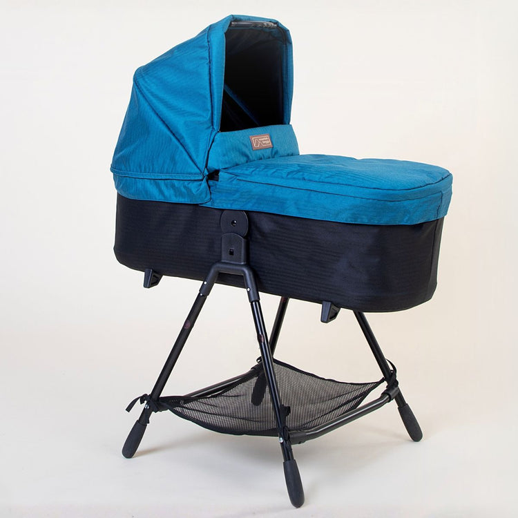 Full shot of Mountain Buggy carry cot plus for duet in ocean blue with stand on white background