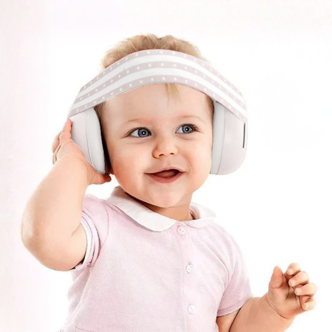 Baby wearing a white visor and pink shirt on a light pink background
