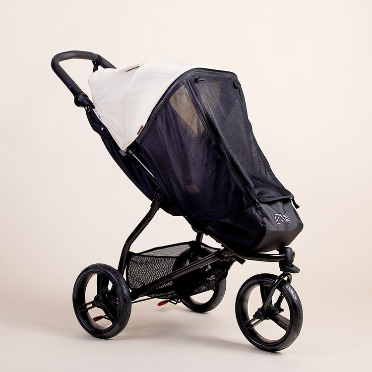Full shot of the Mountain Buggy swift mesh cover ontop of a Mountain Buggy swift in ivory