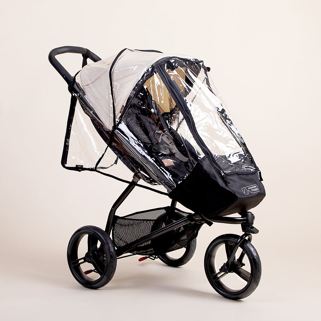 Full shot of the Mountain Buggy swift storm cover on top of a Mountain Buggy swift in ivory