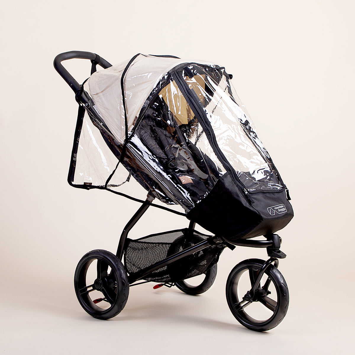 Full shot of the Mountain Buggy swift storm cover on top of a Mountain Buggy swift in ivory
