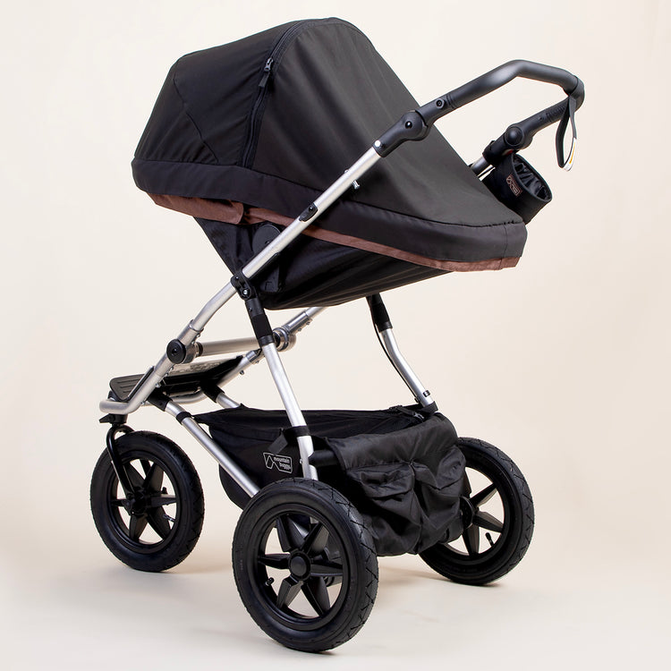 full shot of a mountain buggy urban jungle carrycot plus blackout cover on a mustang brown carrycot plus in toddler mode