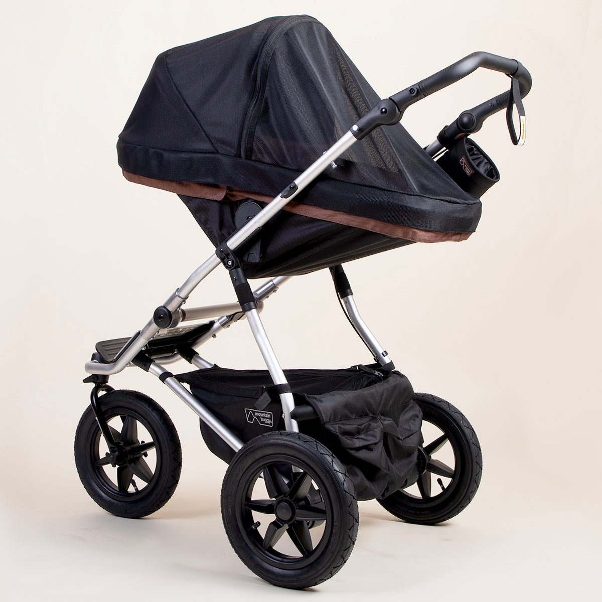 full shot of a mountain buggy urban jungle carrycot plus mesh cover on a mustang brown carrycot plus in toddler mode