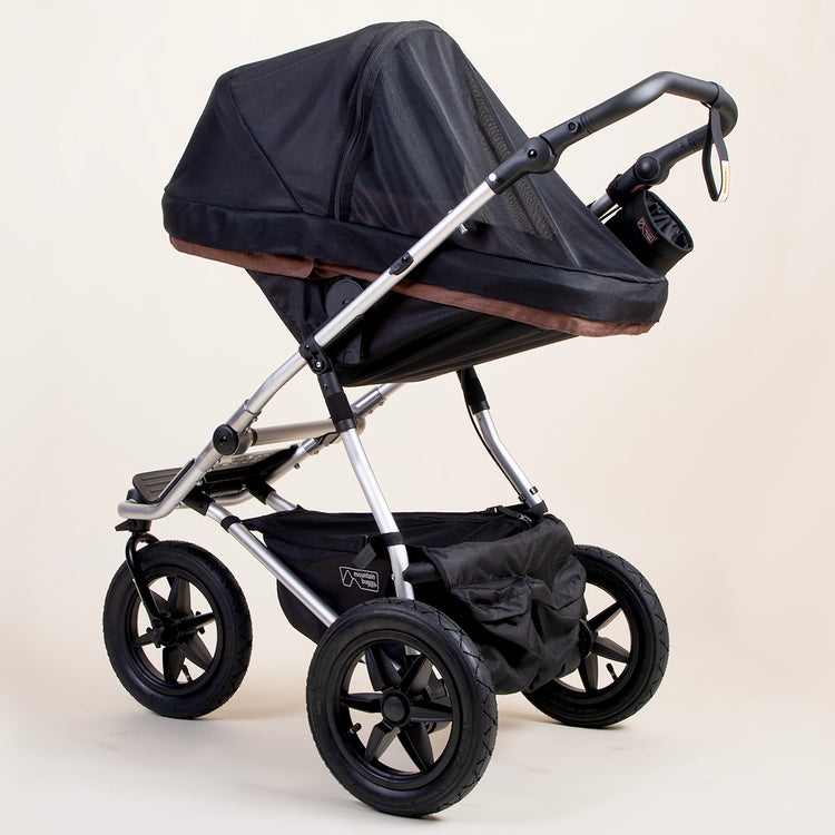 full shot of a mountain buggy urban jungle carrycot plus mesh cover on a mustang brown carrycot plus in toddler mode