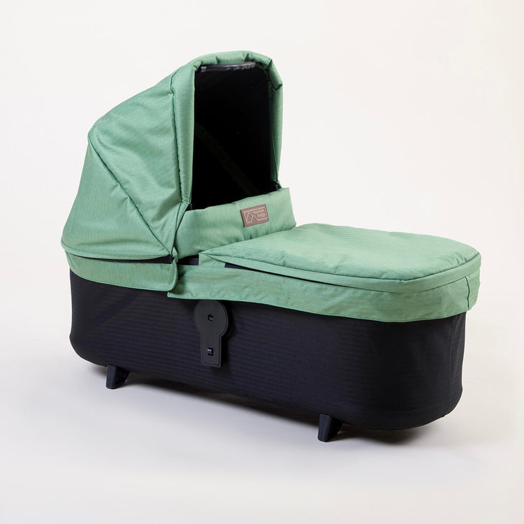 Full shot of Mountain Buggy carry cot plus for duet in matcha green on white background