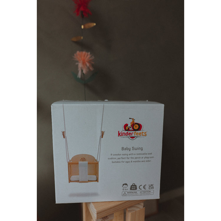 Box of Kinderfeets baby swing on a stand with a dark background