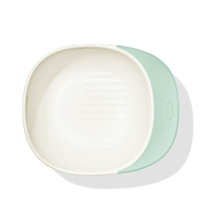Two ceramic bowls, one white and one light green, on a white background