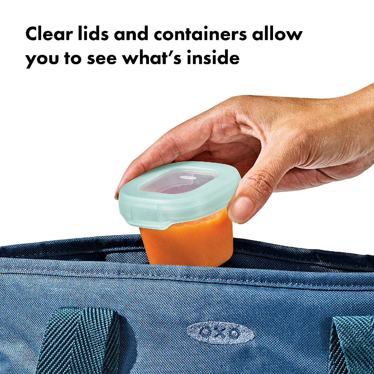 Hand holding a container with a clear lid, showing what's inside, against a blue bag background.
