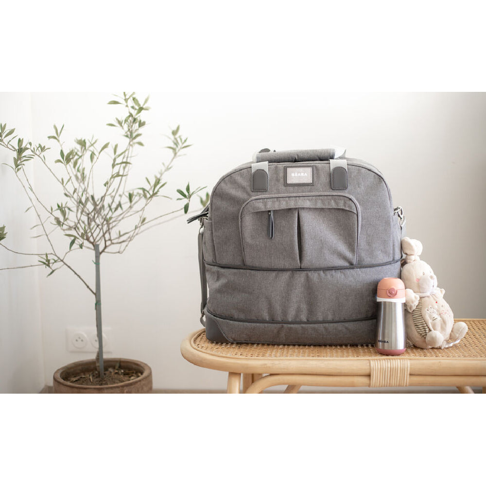 Gray backpack on a wooden table with a plant in the background