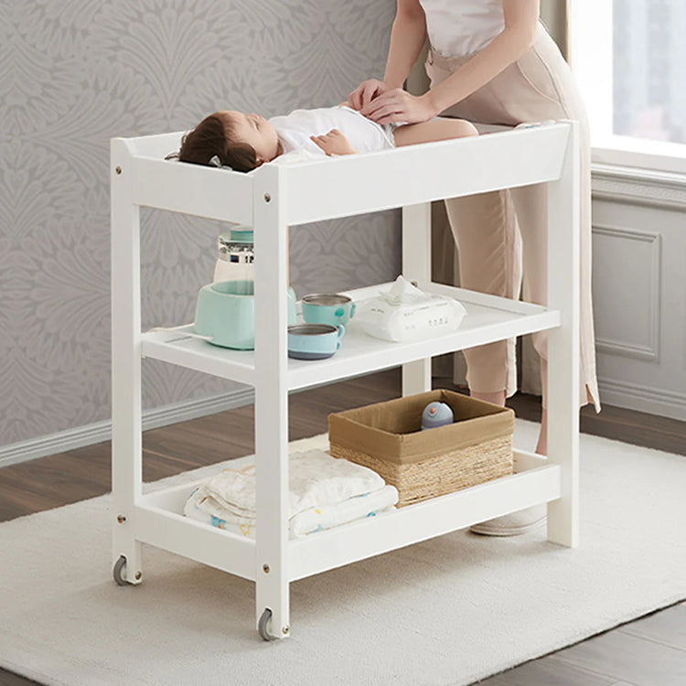 White baby changing table with a child and adult in a room.