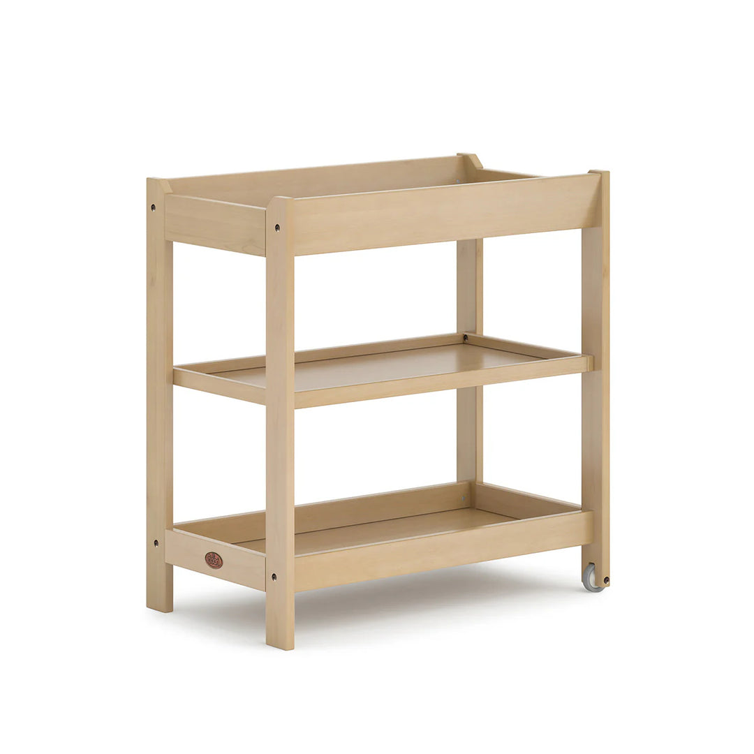 Beige wooden changing table with two shelves on a white background
