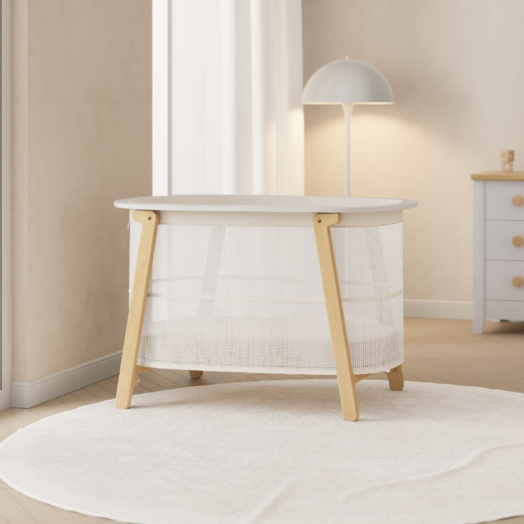Modern baby changing table with wooden legs in a neutral-colored room.