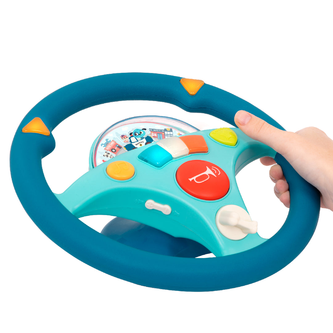 Toy steering wheel with colorful buttons held by a hand on a white background