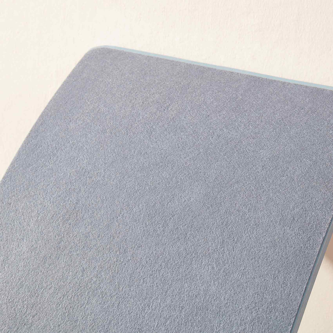 Close-up of a textured gray surface on a light beige background