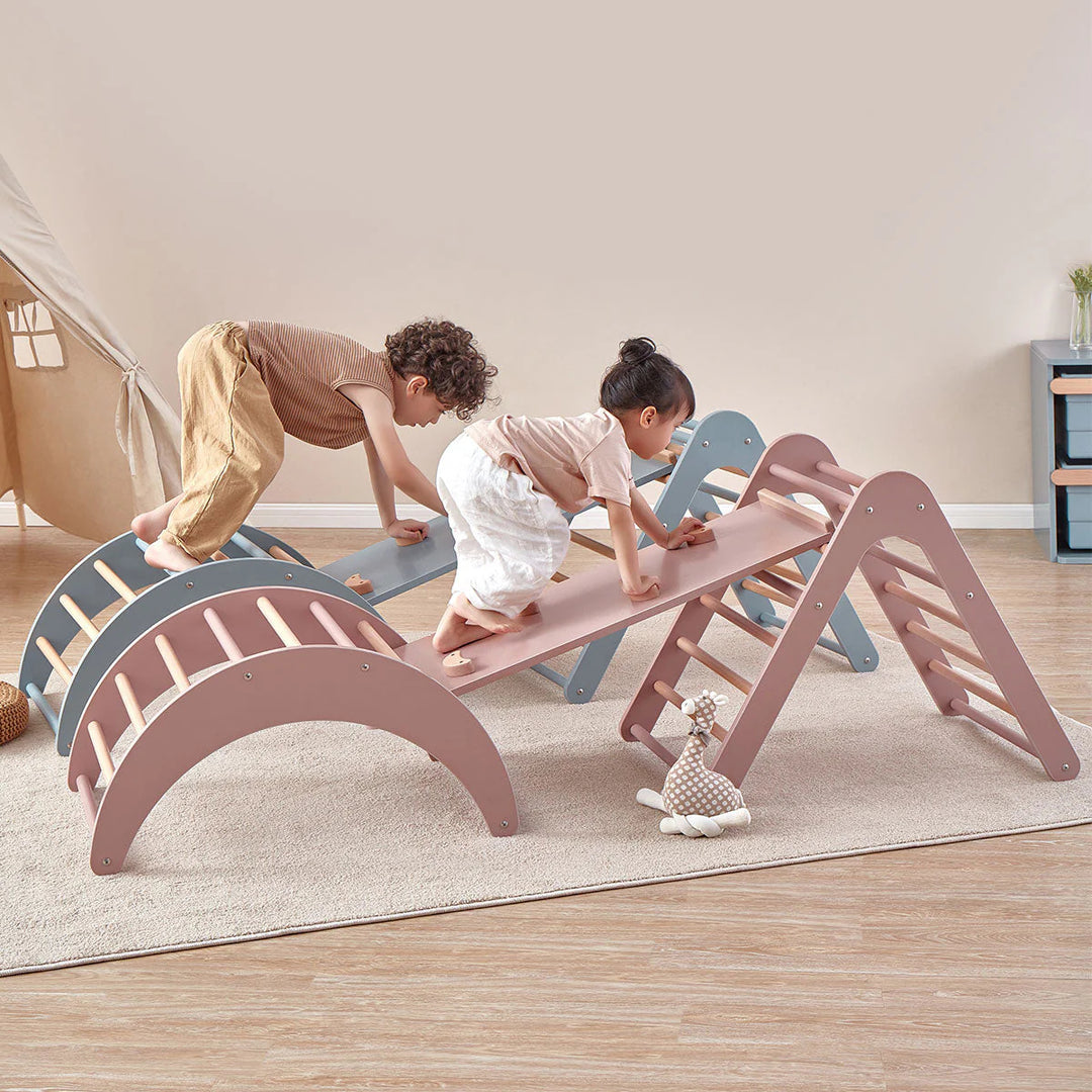 Children playing on a colorful seesaw in a room with a tent and rug.