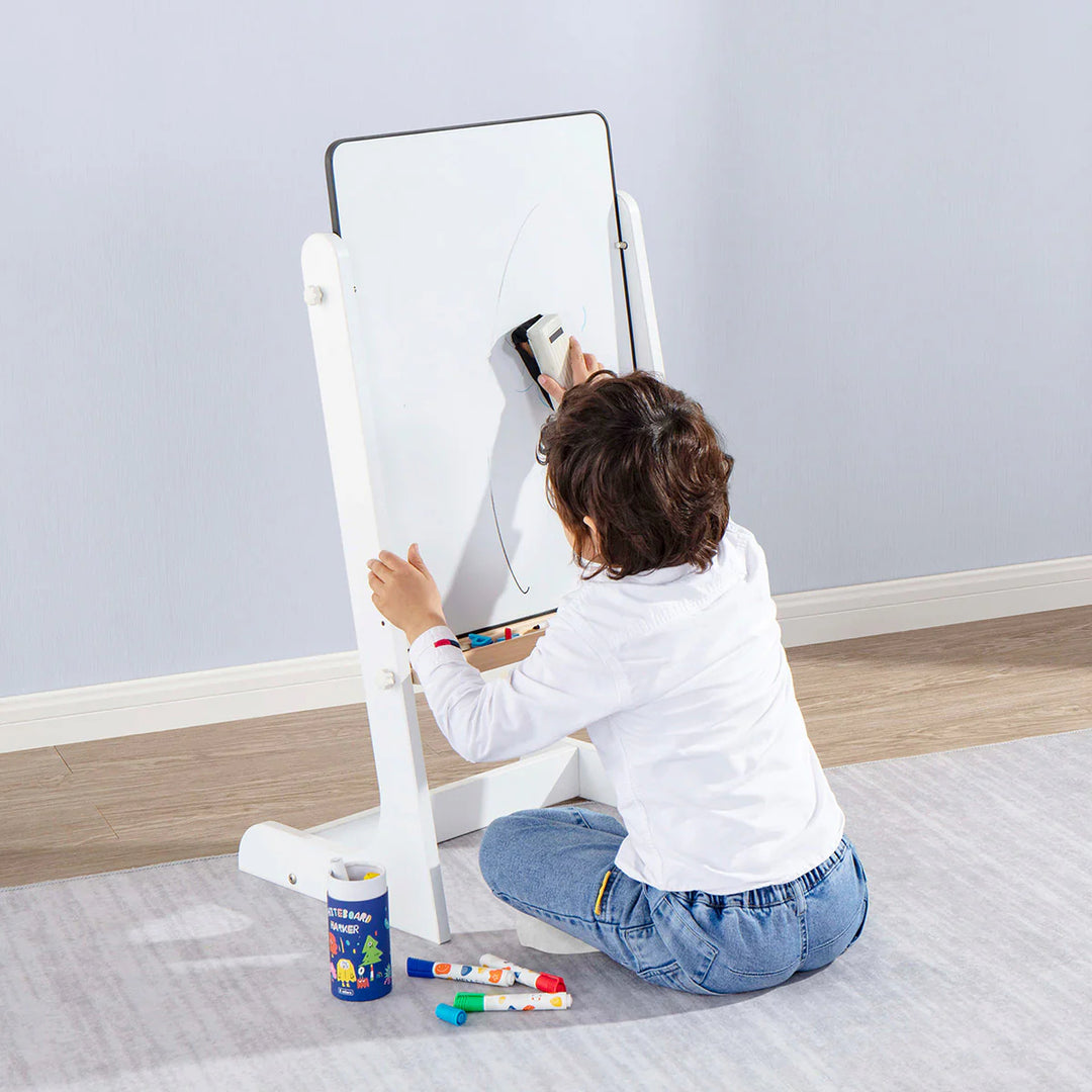 Child using a whiteboard with a stand on a light gray floor.
