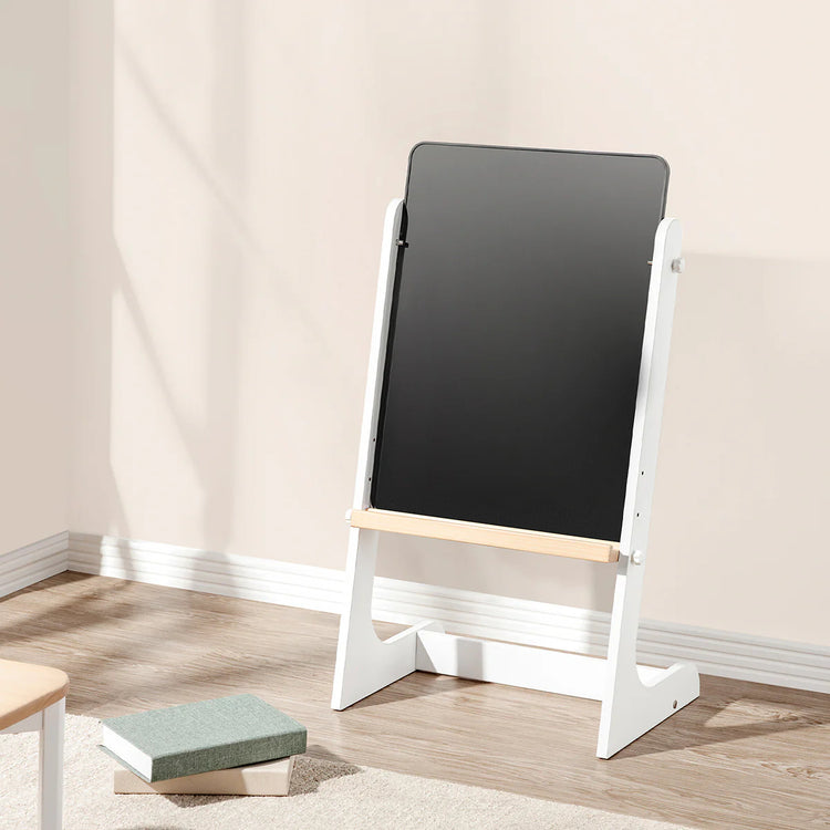 Blackboard with white stand on a wooden floor against a beige wall